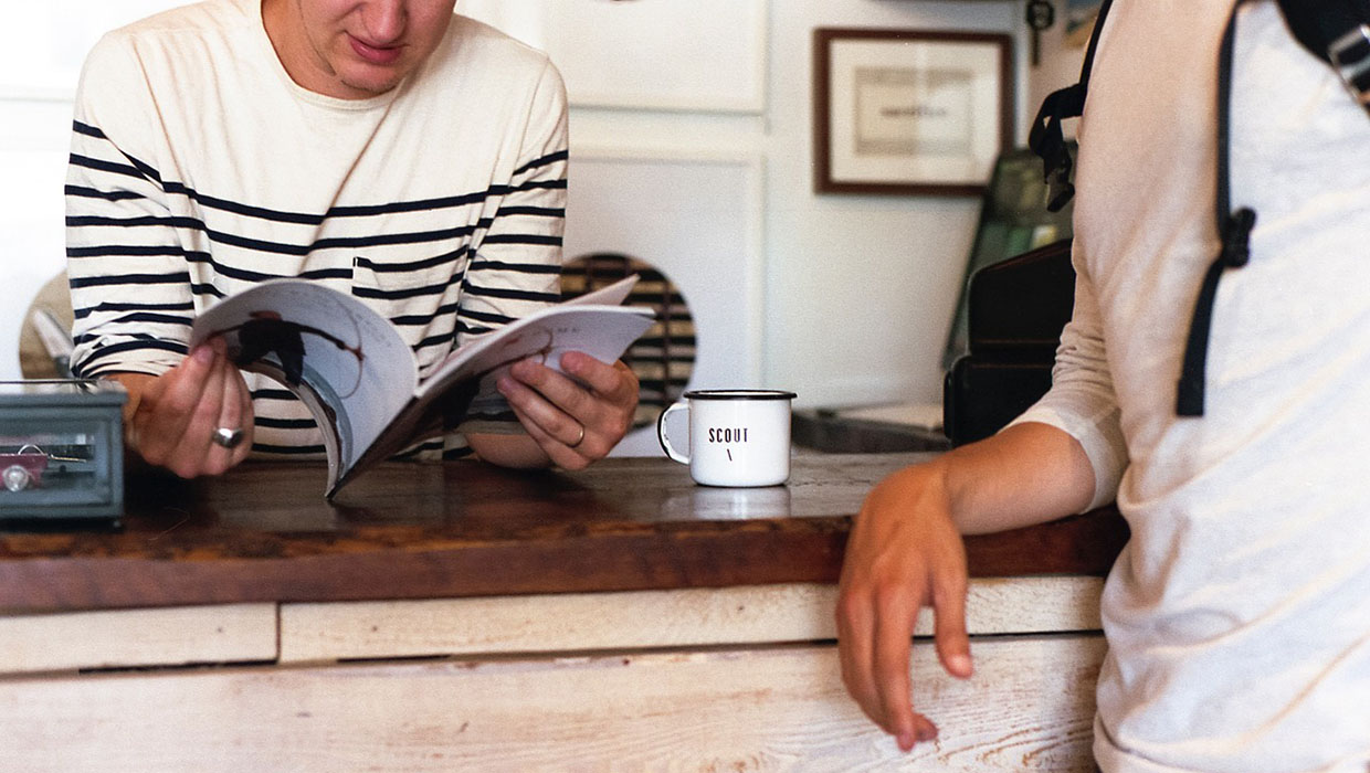 Customer reading a magazine made by a business.